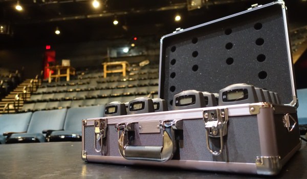 FM receivers in a case against a theatre seating background