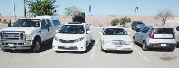 a view of parishioners waiving from their parked cars